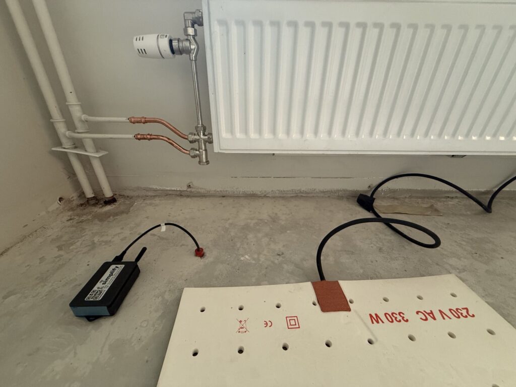 Närbild av radiator och skadeområde där läckaget uppstått. Mätpunkt har installerats i betongkonstruktionen tillsammans med utrustning för distansavläsning, vilket möjliggör kontinuerlig övervakning av fuktnivåerna utan fysiska platsbesök.